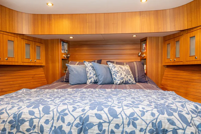 Northern Reign Yacht Photos Pics Luxurious cabin interior of 2020 North Pacific 45 Pilothouse with elegant bedding and wood paneling.