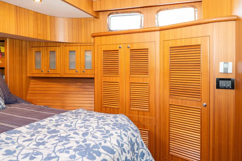 Northern Reign Yacht Photos Pics Interior of 2020 North Pacific 45 Pilothouse with wooden cabinetry and floral bedding.