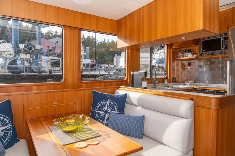 Northern Reign Yacht Photos Pics Luxurious interior of 2020 North Pacific 45 Pilothouse yacht with modern kitchen and dining area.