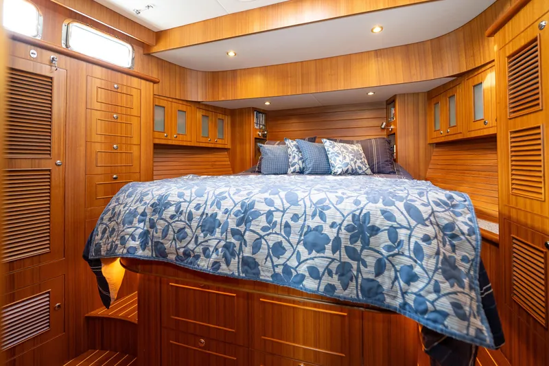 Northern Reign Yacht Photos Pics Luxurious cabin interior of 2020 North Pacific 45 Pilothouse with wood paneling and floral bedding.