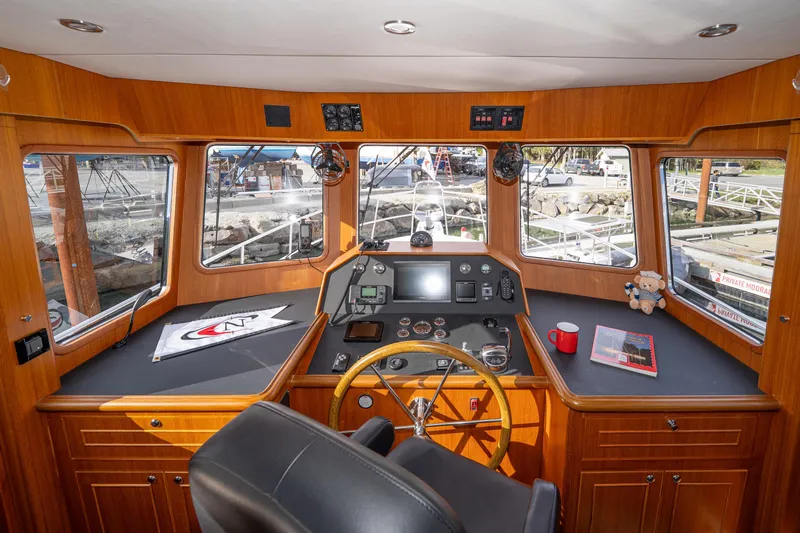 Northern Reign Yacht Photos Pics Pilothouse interior of 2020 North Pacific 45, featuring navigation controls and panoramic windows.