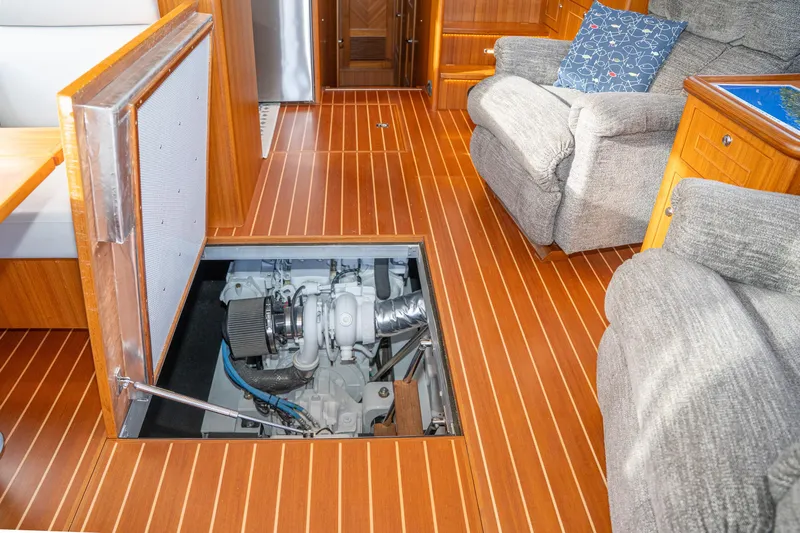 Northern Reign Yacht Photos Pics 2020 North Pacific 45 Pilothouse interior with open engine compartment, wooden flooring, and cozy seating.