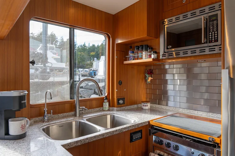 Northern Reign Yacht Photos Pics Modern kitchen in 2020 North Pacific 45 Pilothouse yacht with stainless steel appliances and wood finish.