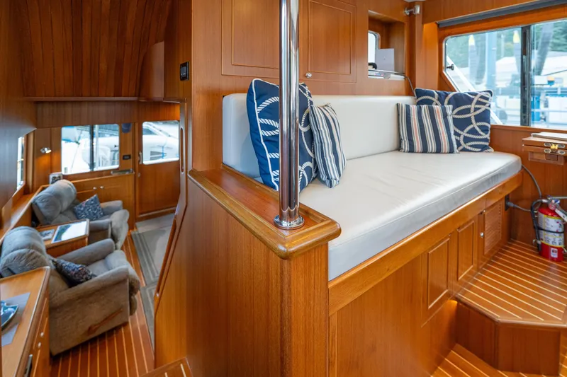 Northern Reign Yacht Photos Pics Interior of 2020 North Pacific 45 Pilothouse with wood finish and striped cushions.