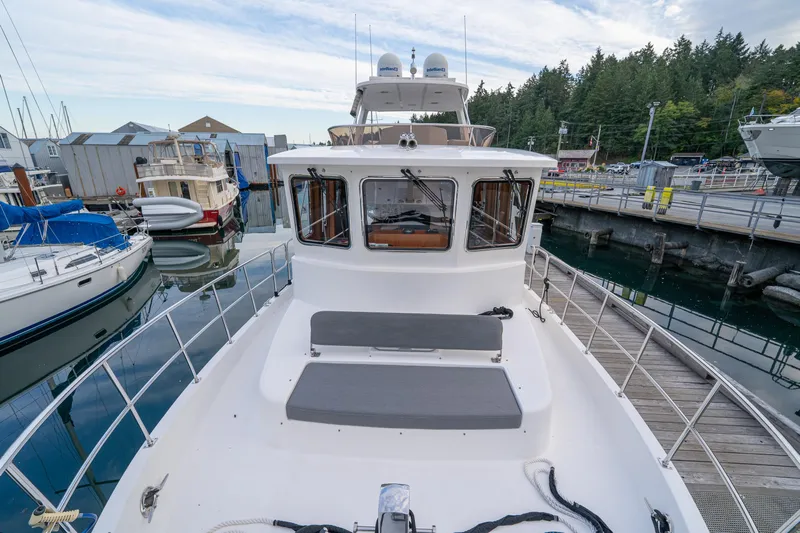 Northern Reign Yacht Photos Pics 2020 North Pacific 45 Pilothouse yacht docked at a marina, surrounded by other boats.