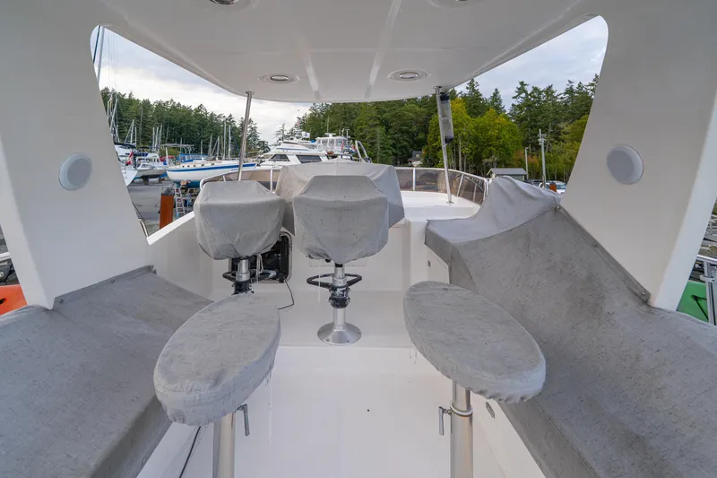 Northern Reign Yacht Photos Pics 2020 North Pacific 45 Pilothouse boat interior with covered seating and helm chairs.