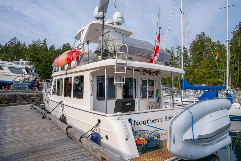 Northern Reign Yacht Photos Pics North Pacific 45 Pilothouse 2020 docked, featuring outdoor equipment and Canadian flags.