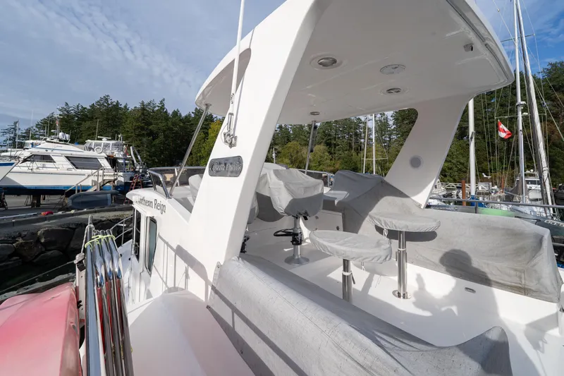 Northern Reign Yacht Photos Pics 2020 North Pacific 45 Pilothouse yacht docked, featuring covered seating and scenic marina backdrop.