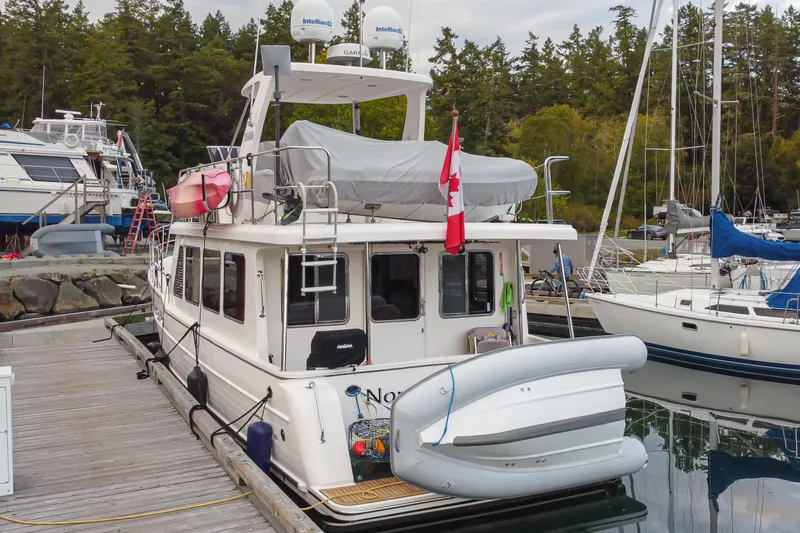 Northern Reign Yacht Photos Pics 2020 North Pacific 45 Pilothouse docked, featuring Canadian flag and inflatable boat.