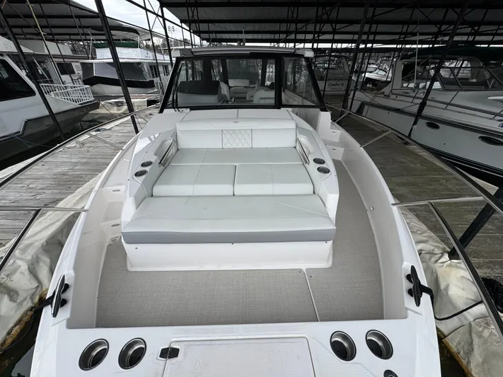  Yacht Photos Pics 2023 Regal 360 Grande Coupe boat with spacious seating in a marina setting.