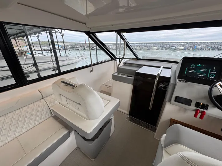  Yacht Photos Pics 2023 Regal 360 Grande Coupe interior with modern helm and seating, overlooking marina.