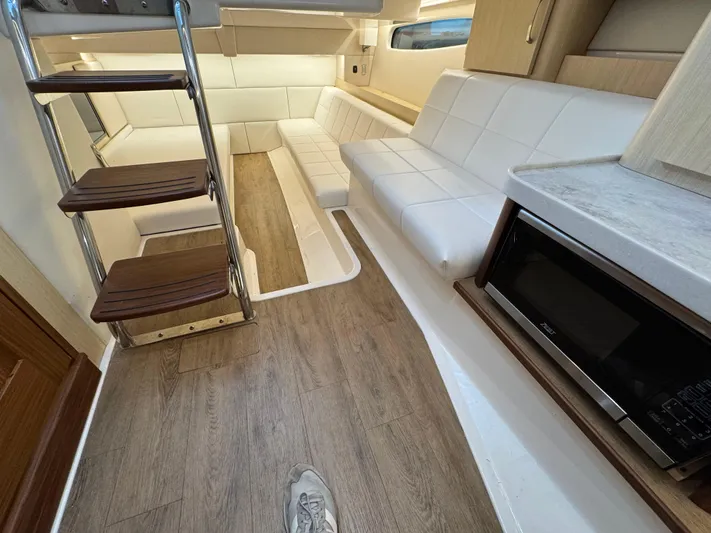  Yacht Photos Pics Interior of 2023 Regal 360 Grande Coupe with white seating and wooden flooring.