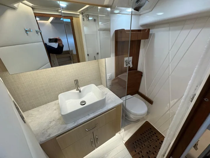 Yacht Photos Pics 2023 Regal 360 Grande Coupe bathroom with modern sink, toilet, and wooden accents.