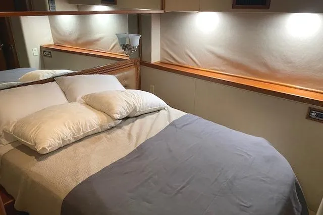 Swamp Fox Yacht Photos Pics Cozy bedroom interior of 1989 Buddy Davis 61 Sportfish yacht with soft lighting.