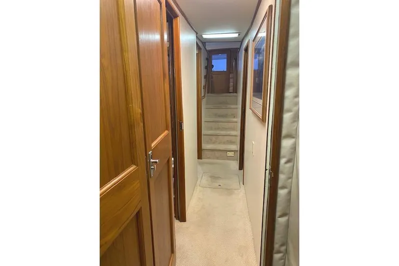 Swamp Fox Yacht Photos Pics Interior hallway of 1989 Buddy Davis 61 Sportfish yacht with wooden doors and carpeted floor.