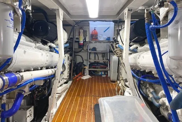 Swamp Fox Yacht Photos Pics Engine room of 1989 Buddy Davis 61 Sportfish with dual engines and wooden flooring.