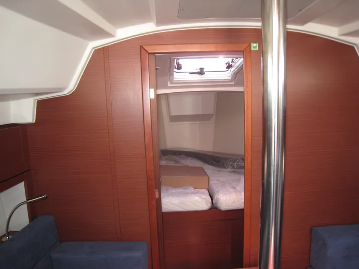 In Stock Yacht Photos Pics Interior of 2025 Hanse 348 yacht cabin with wooden finish and cozy bedding.