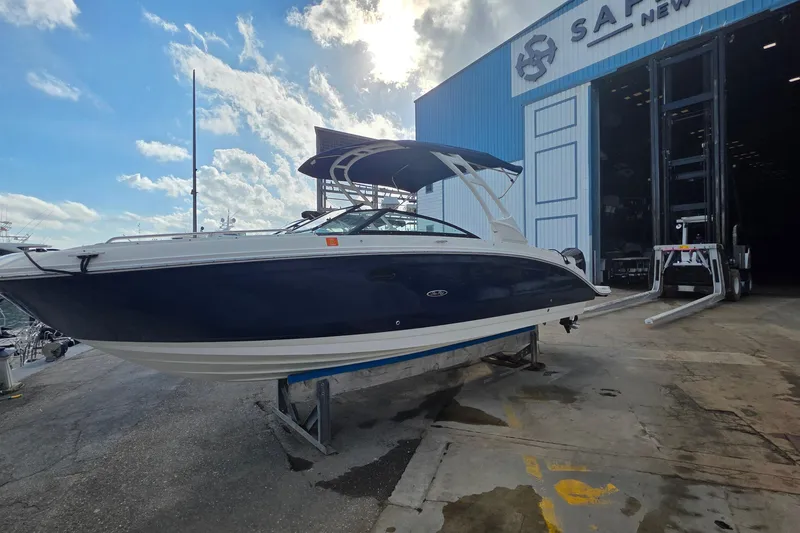  Yacht Photos Pics 2021 Sea Ray SDX 290 Outboard boat outside a blue warehouse under a cloudy sky.