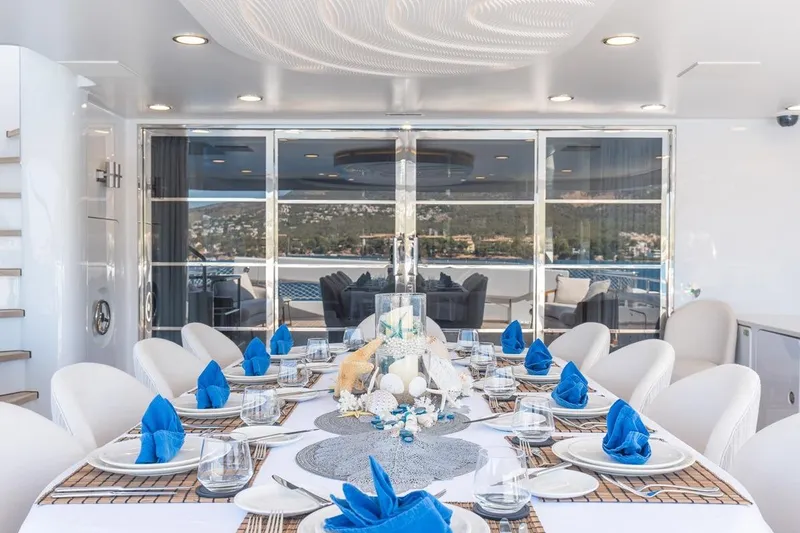 Titian Pearl Yacht Photos Pics Luxurious dining setup on CRN Magnifica yacht, 2001 model, with elegant blue accents.