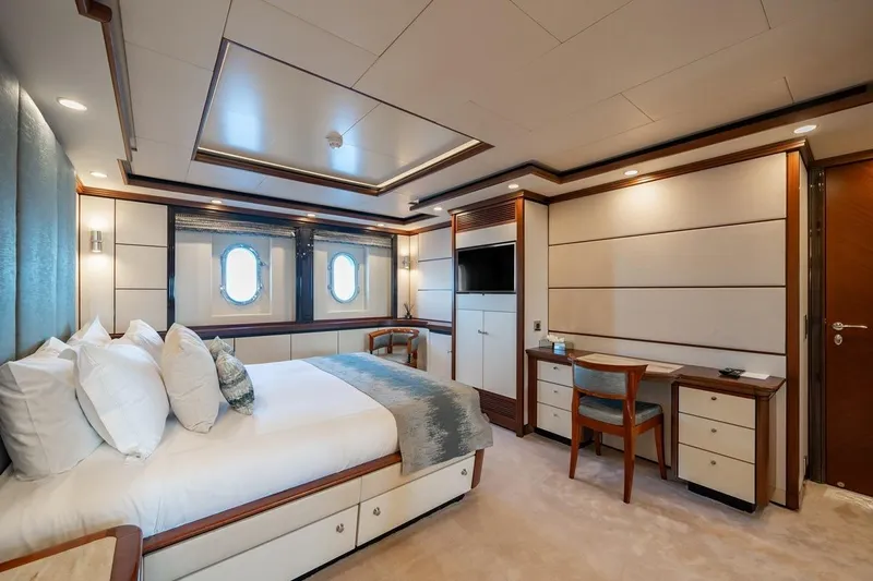 Titian Pearl Yacht Photos Pics Luxurious yacht bedroom interior on CRN Magnifica, 2001 model, featuring elegant furnishings and porthole windows.