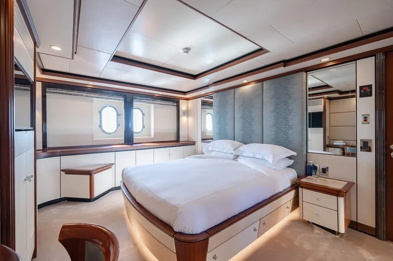 Titian Pearl Yacht Photos Pics Luxurious bedroom interior on CRN Magnifica yacht, 2001 model, featuring elegant design and porthole windows.