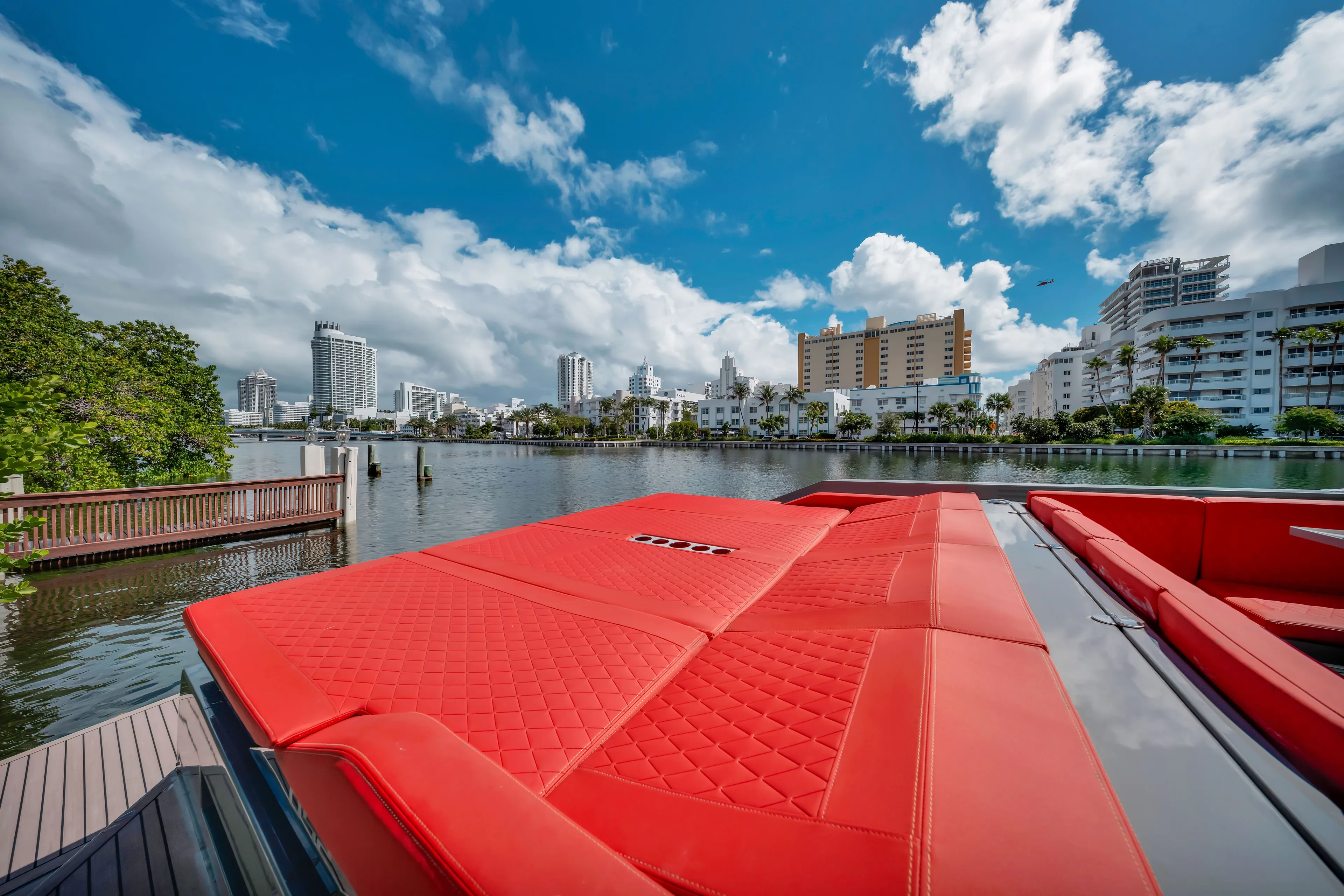 Painkiller Yacht Photos Pics 2023 De Antonio Yachts D42 Open with red seating, city skyline, and waterfront view.