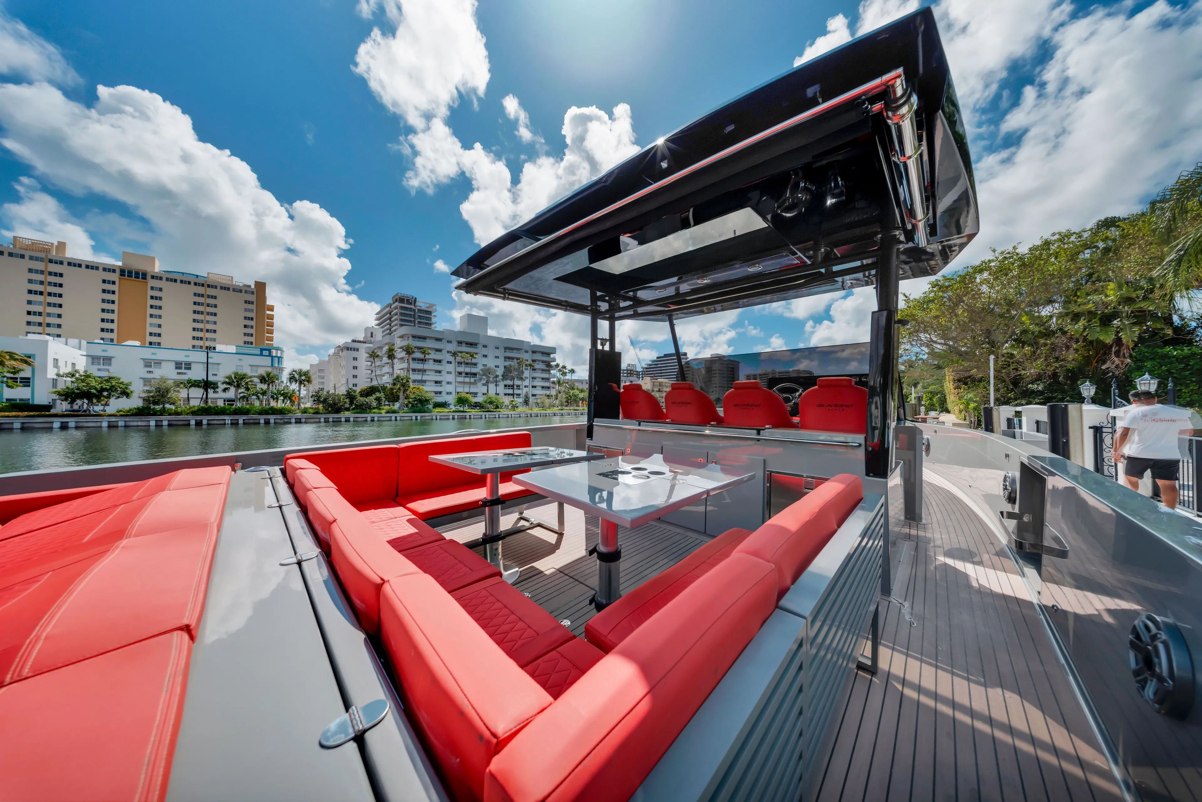 Painkiller Yacht Photos Pics 2023 De Antonio Yachts D42 Open with red seating, docked in a scenic urban waterfront.