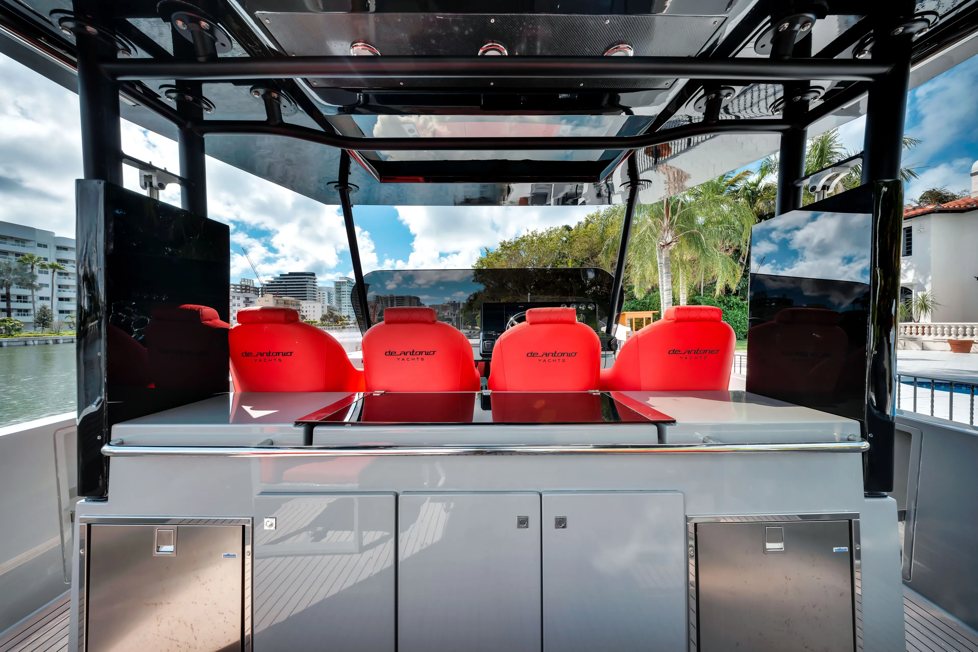 Painkiller Yacht Photos Pics De Antonio Yachts D42 Open 2023 with red seats and sleek design, docked by palm trees.