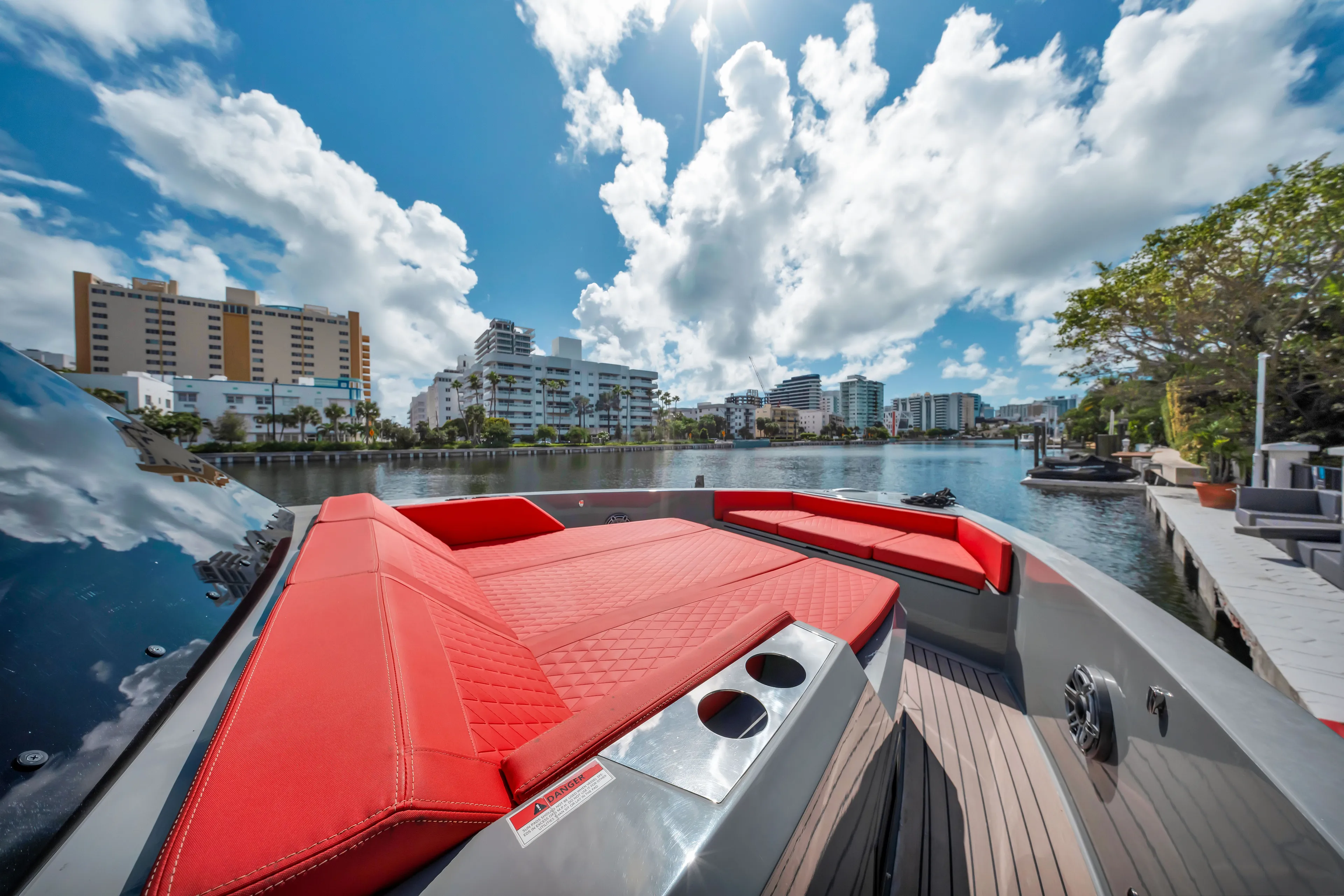 Painkiller Yacht Photos Pics 2023 De Antonio Yachts D42 Open with red seating, docked in a scenic urban waterfront.