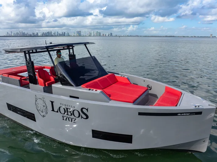 Painkiller Yacht Photos Pics 2023 De Antonio Yachts D42 Open with red seating, cruising near city skyline.