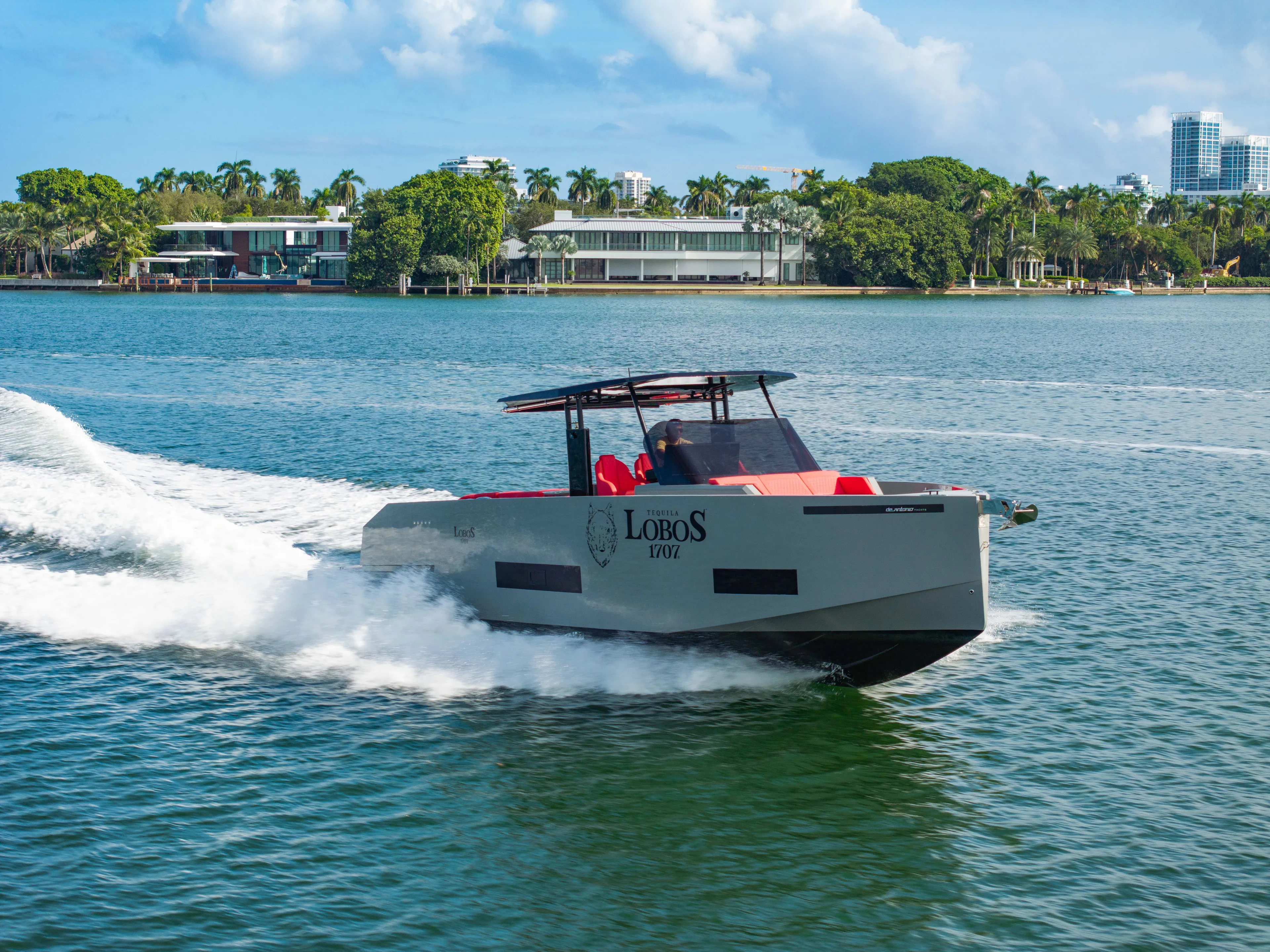 Painkiller Yacht Photos Pics 2023 De Antonio Yachts D42 Open cruising on a sunny day near waterfront homes.