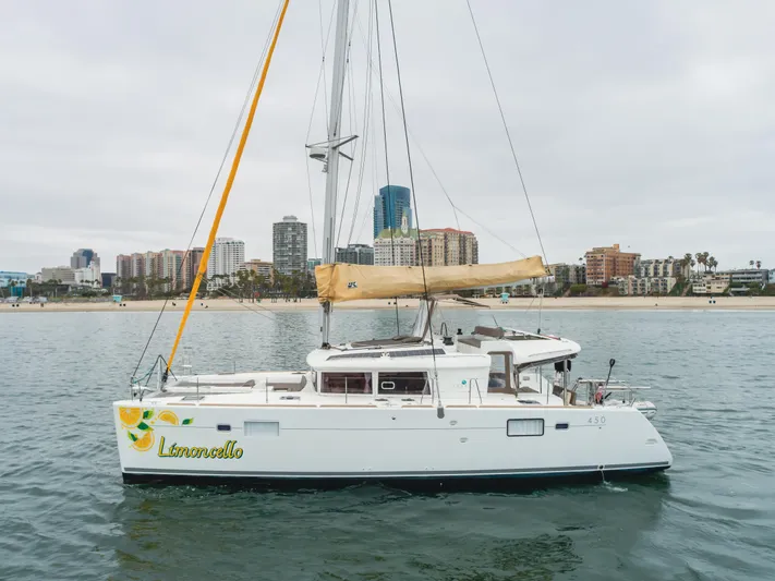 Limoncello Yacht Photos Pics 2016 Lagoon 450F catamaran named "Limoncello" sailing near a city skyline.
