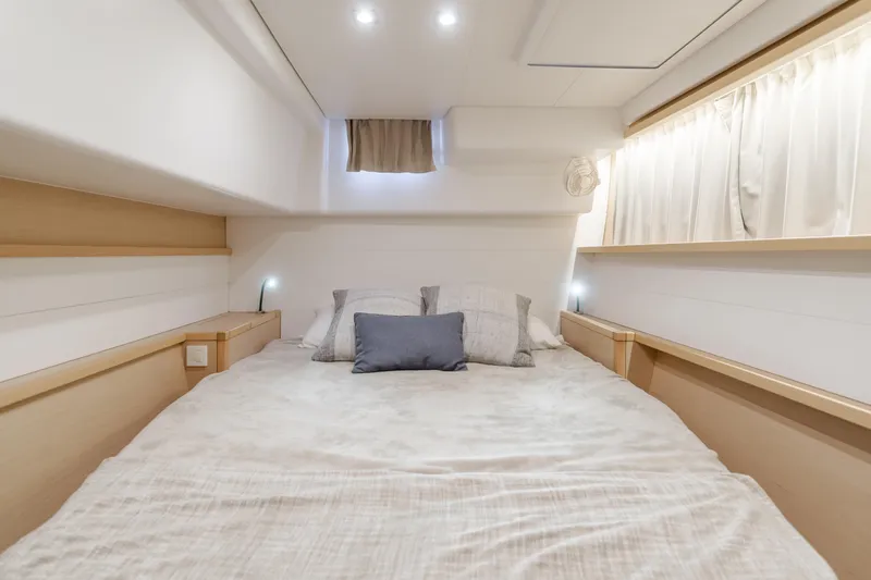 Limoncello Yacht Photos Pics Luxurious cabin interior of 2016 Lagoon 450F catamaran with cozy bedding and ambient lighting.