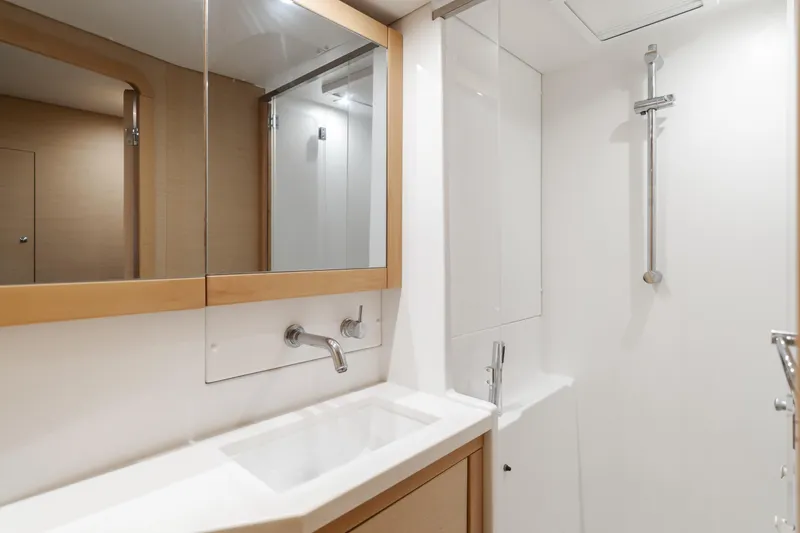 Limoncello Yacht Photos Pics Modern bathroom in 2016 Lagoon 450F yacht with sleek fixtures and mirrored cabinets.