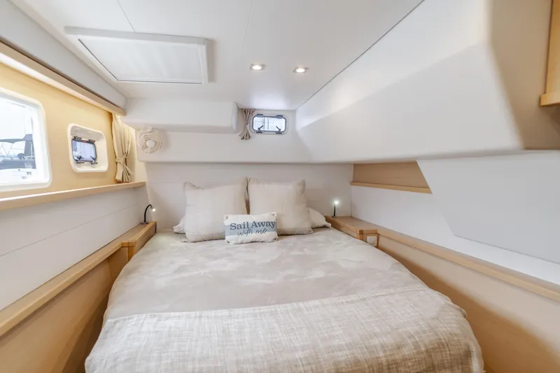 Limoncello Yacht Photos Pics Luxurious cabin interior of 2016 Lagoon 450F catamaran with cozy bedding and natural light.