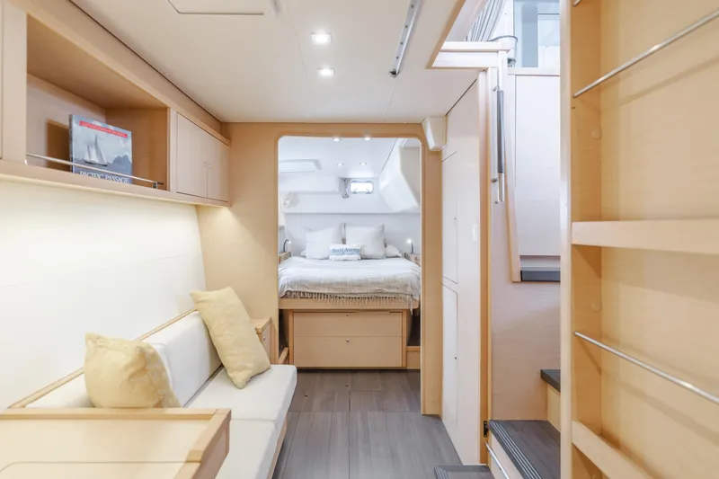 Limoncello Yacht Photos Pics Luxurious interior of 2016 Lagoon 450F catamaran, featuring cozy seating and elegant bedroom.