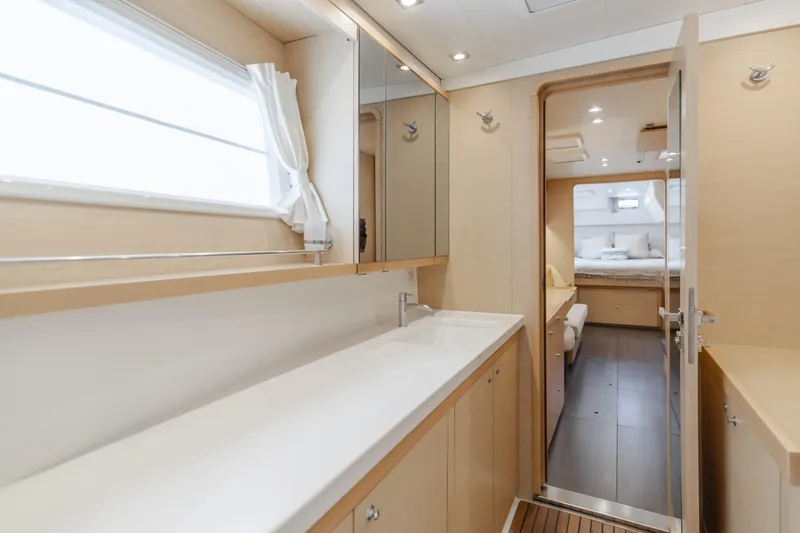 Limoncello Yacht Photos Pics Luxurious interior of 2016 Lagoon 450F yacht, featuring a spacious bathroom and bedroom.