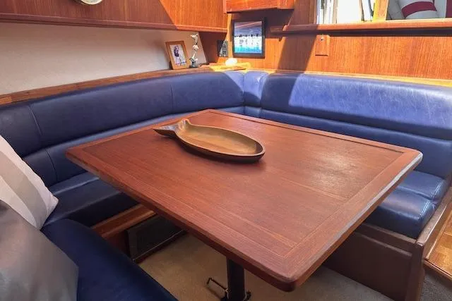 Arete Yacht Photos Pics 1988 Viking 45 Convertible yacht interior with wooden table and blue seating.
