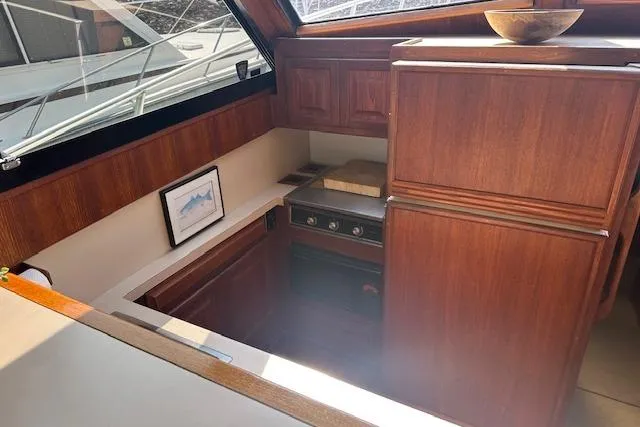 Arete Yacht Photos Pics 1988 Viking 45 Convertible yacht interior with wooden cabinetry and compact kitchen area.
