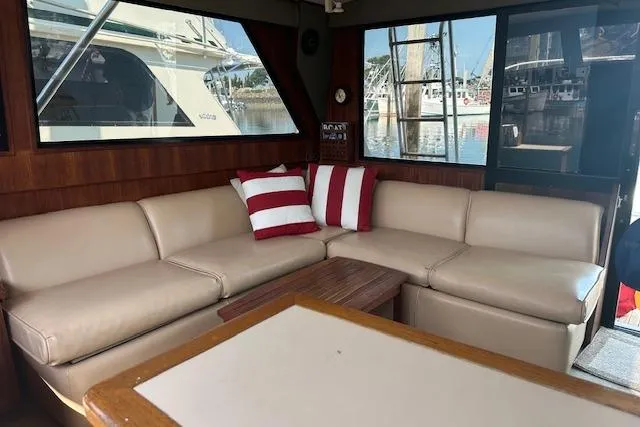 Arete Yacht Photos Pics Interior of 1988 Viking 45 Convertible yacht with beige leather seating and striped cushions.