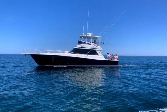 Arete Yacht Photos Pics 1988 Viking 45 Convertible yacht cruising on open sea under clear blue sky.