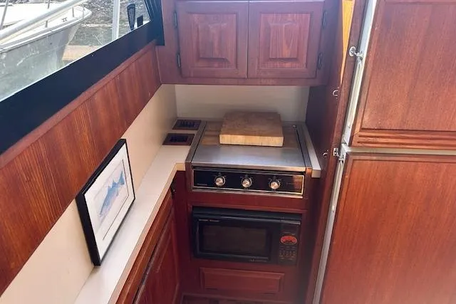 Arete Yacht Photos Pics 1988 Viking 45 Convertible yacht kitchen with wooden cabinets and modern appliances.