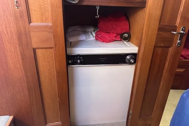 Arete Yacht Photos Pics Laundry area inside 1988 Viking 45 Convertible boat with wooden cabinetry and towels.