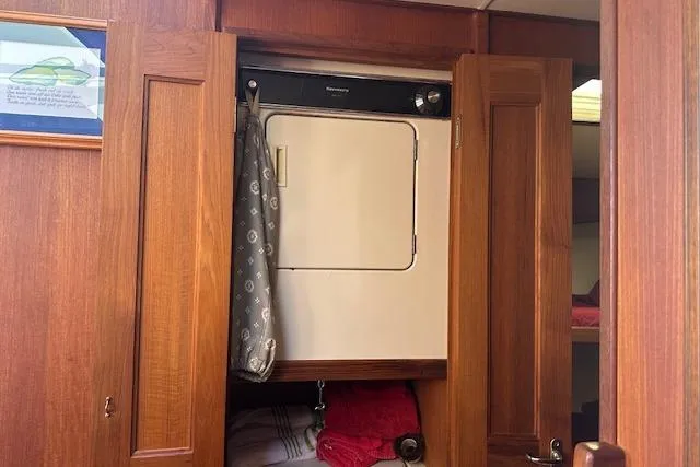 Arete Yacht Photos Pics 1988 Viking 45 Convertible interior with wooden cabinetry and built-in laundry unit.