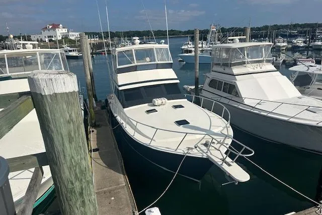 Arete Yacht Photos Pics 1988 Viking 45 Convertible yacht docked at a marina, surrounded by other boats.