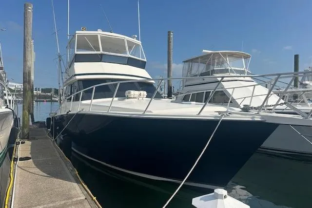 Arete Yacht Photos Pics 1988 Viking 45 Convertible yacht docked at marina under clear blue sky.