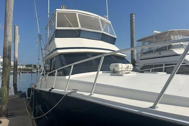 Arete Yacht Photos Pics 1988 Viking 45 Convertible yacht docked at marina under clear blue sky.