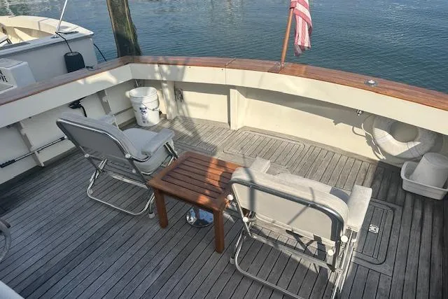 Arete Yacht Photos Pics 1988 Viking 45 Convertible yacht deck with chairs and table, overlooking water.