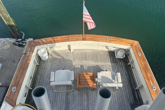 Arete Yacht Photos Pics 1988 Viking 45 Convertible yacht deck with chairs, table, and American flag.