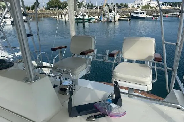 Arete Yacht Photos Pics 1988 Viking 45 Convertible yacht helm with two chairs, overlooking marina.
